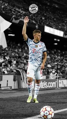 a soccer player is on the field with his hand in the air and he is about to kick the ball