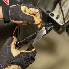 a pair of work gloves holding an electrical wire