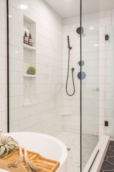 a bathroom with a stand up shower and wooden trays on the bathtub in front of it