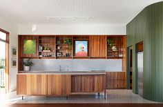 a kitchen with wooden cabinets and stainless steel sink in the center, along with hardwood flooring