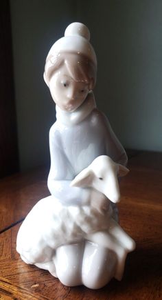 a white figurine sitting on top of a wooden table