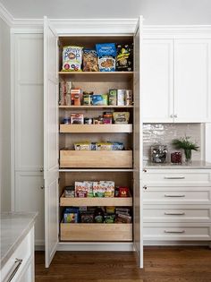 an organized pantry in a white kitchen with wood flooring and wooden shelves filled with food