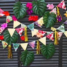 a bunch of flowers and leaves are hanging on a wall with some tassels