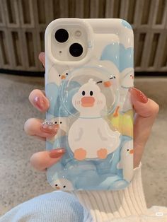 a woman holding up her phone case with an image of a duck and penguin on it