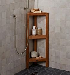 a wooden shelf in the corner of a shower