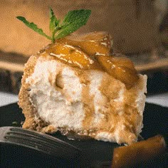 a piece of cheesecake on a black plate with a fork