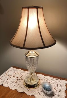 a lamp that is sitting on top of a table with a doily underneath it