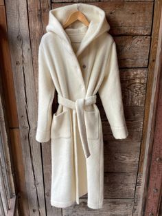 Cream white long lambswool robe coat with hood, pockets and tie belt Pure wool milk white hooded robe coat soft and warm  Beautiful gift This piece is versatile for both Men's & Women's outdoor fashion, and can be used insider in cooler winter weather to keep warm while reading on the couch. CARE: Hand-wash and hang to dry, light iron if needed, or dry clean. SIZE: S/M/L/XL COMPOSITION: 100% lambswool If you like this, bookmark & browse my shop for other items! Save, Share, Pin or Post! Browse t Long White Wool Coat, Cozy Hooded Robe For Winter, Cozy Hooded Winter Robe, White Long Sleeve Winter Robe, Cozy White Robe For Winter, Cozy White Winter Robe, Womens Outdoor Fashion, Cashmere Coat Women, Off White Coat