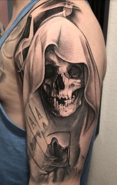 a man's arm with a black and white tattoo on it, featuring a skull