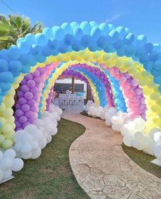 an arch made out of balloons in the shape of a rainbow