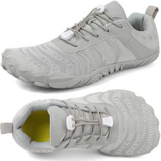 a pair of grey sneakers with white laces on the side and yellow soles