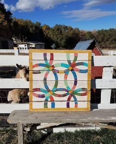 a horse standing next to a fence with a quilt on it