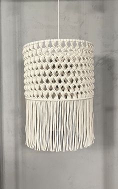 a white chandelier hanging from the ceiling with tassels and beads on it