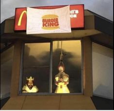 a mcdonald's burger king restaurant with two mannequins in the window