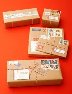 four wrapped packages with stamps on them sitting on an orange surface