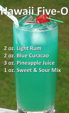 a tall glass filled with blue curacao and topped with a cherry