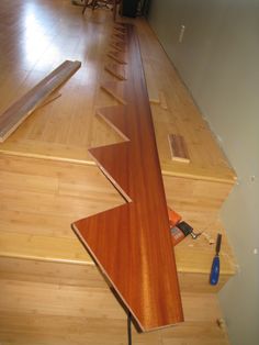 a wooden floor that has been stripped off and is laying on the ground with tools