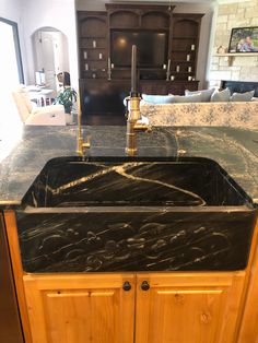 a kitchen sink with black marble counter tops