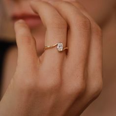 a woman's hand with a ring on it and a diamond in the middle