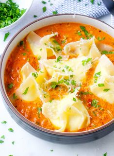 two bowls filled with pasta and sauce on top of a table