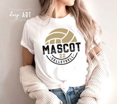 a woman wearing a t - shirt that says mascot volleyball on it and has her hands in her pockets