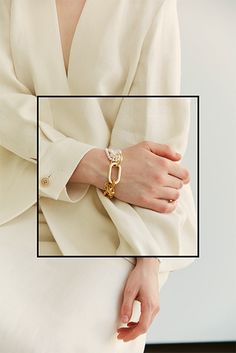 a woman wearing a white coat and gold bracelet