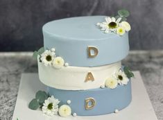 three tiered cake decorated with daisies and flowers