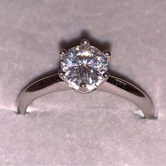 a close up view of a ring with a diamond in the center on a white background