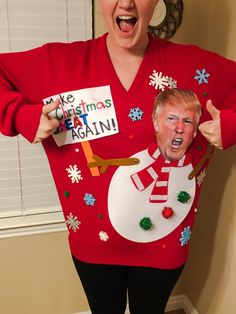 a woman in a ugly sweater holding up a sign that says make christmas great again