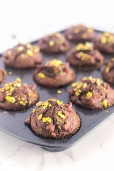 chocolate cupcakes with yellow sprinkles in a muffin tin