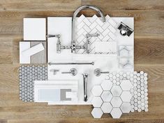 bathroom accessories laid out on top of a wooden floor with white and gray tiles in the middle