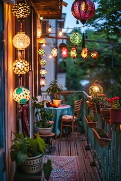 Cozy balcony decorated with colorful hanging lanterns, plants, and patterned rug, creating an inviting outdoor space. Hygge Balcony Ideas, Small Balcony Hanging Lights, Lights Balcony Apartment, Small Balcony Decor Lights, Apartment Plants