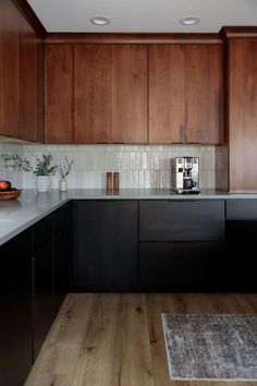 a kitchen with wooden cabinets and white counter tops, along with a rug on the floor