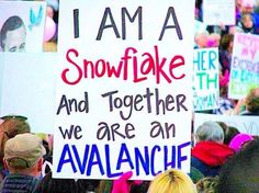 a group of people holding up signs in front of a crowd at a protest for snowflake