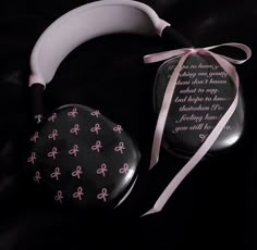 two black and white items with pink designs on them, one has a ribbon tied around it