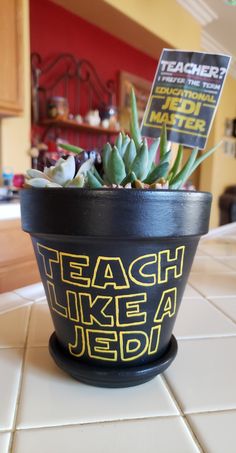 a potted plant sitting on top of a white tile floor next to a sign