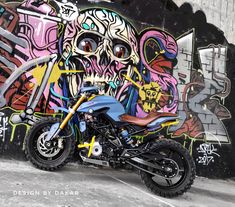 a motorcycle parked in front of a graffiti covered wall