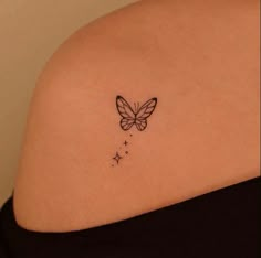 a woman's back shoulder with a butterfly and stars tattoo on the left side