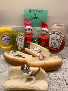 hot dogs, ketchup and mustard are on the counter next to elfs