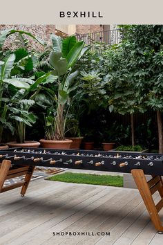 A large black outdoor football table with wooden legs set on a wooden deck surrounded by green large plants in a large pots Modern Game Room, Party Game Ideas, Football Table, Outdoor Party Games, Community Space, Play Spaces, Game Ideas, Outdoor Party, Party Game