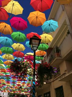 many colorful umbrellas are hanging from the ceiling