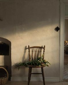 a chair sitting in front of a wall with a potted plant on top of it