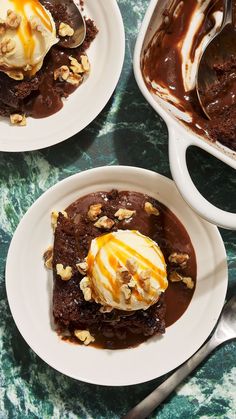 three white plates topped with brownies covered in ice cream and toppings on top of a green table