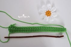 two crocheted items are laying next to each other on a white surface with a flower in the middle