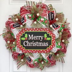 a christmas wreath on the front door with candy wrapped in red, green and white