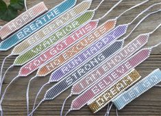 four cross stitch bookmarks on a wooden table