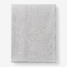 a gray blanket folded on top of a white wall