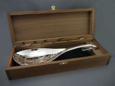 a silver spoon in a wooden box with its lid open