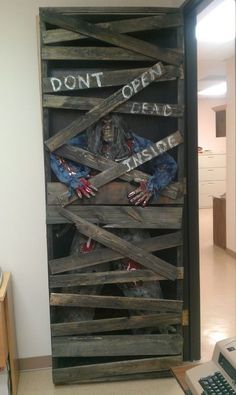 a large wooden crate with a zombie in it's arms and hands on the door