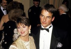 a man in a tuxedo standing next to a woman wearing a beaded dress